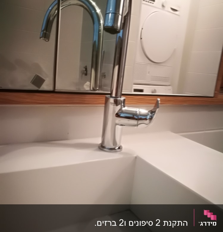ברז נירוסטה מותקן על כיור לבן בחדר אמבטיה